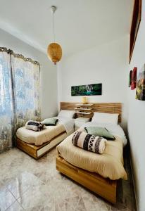two beds in a room with white walls at Infinity Experience Casa Vacanza Incantevole con Terrazzo in Scala