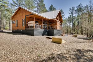 a large wooden house in the middle of a forest at Family-Friendly Broken Bow Cabin Rental with Hot Tub in Broken Bow
