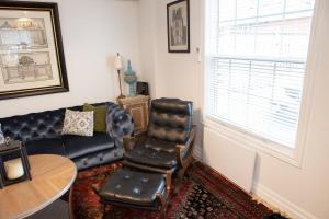 a living room with a leather couch and a chair at 2Bdrm Victorian Style Tiny Home - long stays U7 in Burlington