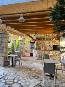 a patio with tables and chairs and a stone wall at Arial Trinity Suites in Vlorë