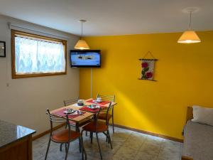 comedor con mesa y sillas contra una pared amarilla en Las Vistas, en San Martín de los Andes 14 fotos más
