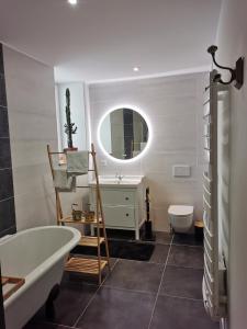 a bathroom with a tub and a sink and a mirror at Chambre de l'Iris in Sainte-Croix-sur-Mer