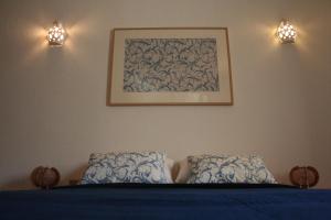 - un lit avec deux oreillers et une photo sur le mur dans l'établissement Albufeira Beach - Tranquilidade junto à praia e ao centro!, à Albufeira