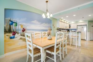 a dining room with a table and a painting of the ocean at Adagio 402 in Ocean City