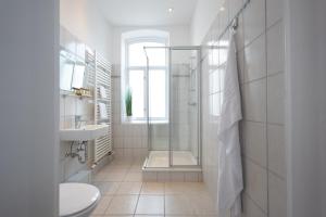 y baño con ducha, aseo y lavamanos. en Maritas Logierhaus (Haus Braunschweig) en Westerland