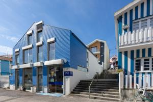 Apartamento Férias (Apartamento Norte) في كوستا نوفا: مبنى ازرق يوجد به درج امام مبنى