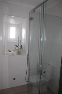 baño con ducha y aseo y ventana en My home en Cercal