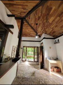 Habitación grande con techo con vigas de madera. en Goura House Ilhabela, en Ilhabela