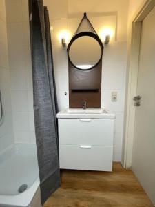 a bathroom with a sink and a mirror and a tub at Apartment Blattgold in Schwabach