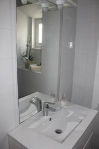 a white bathroom with a sink and a mirror at My home in Cercal +13 photos