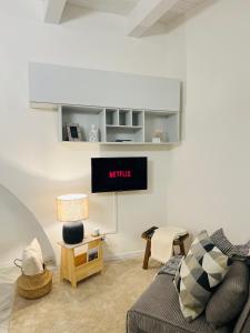 a living room with a couch and a tv on the wall at [Ferrara Centro - SABI APT] in Ferrara