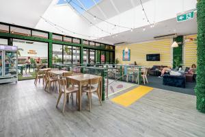 a restaurant with tables and chairs in a cafeteria at Tequila Sunrise Hostel Surfers Paradise in Gold Coast