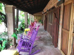 Beach Lover's Paradise في Petatlán: صف من الكراسي الأرجوانية التي تجلس على الشرفة
