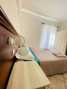 Pokój z łóżkiem i stołem z lampką w obiekcie Mamamia #Lipari w mieście Lipari