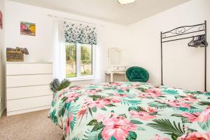 - une chambre dotée d'un lit avec un couvre-lit floral dans l'établissement Dickens, à Ryde