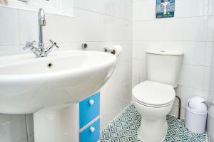 a bathroom with a white sink and a toilet at Dickens in Ryde +39 photos