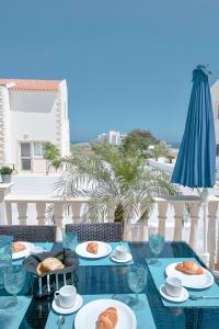 a table with plates of food on a balcony at Blue Crystal Seaview in Protaras