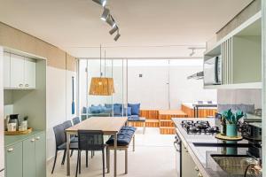 a kitchen and dining room with a table and chairs at Cobertura Premium Hidro 3Quartos 2Vagas Ubatuba in Ubatuba