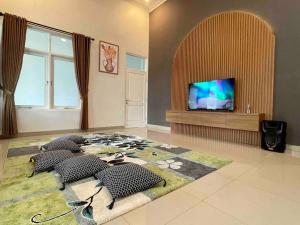 a living room with a tv and a rug at Dhanis House Bogor in Cibanawak