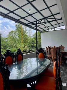 ein Esszimmer mit einem Glastisch und Stühlen in der Unterkunft Dhanis House 7 Bedroom Villa in Cibanawak