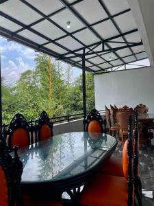 a dining room with a glass table and chairs at Dhanis House 8 Bedroom Villa in Cibanawak