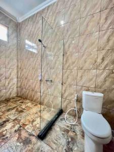 ein Bad mit einem WC und einer Glasdusche in der Unterkunft Dhanis House 7 Bedroom Villa in Cibanawak