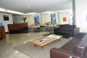 a lobby with a couch and tables and chairs at Studio TOP pra homeoffice, internet voando in Macaé +42 photos