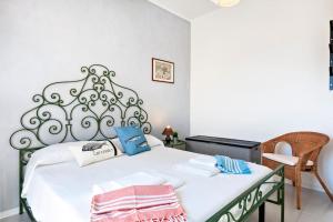 una camera da letto con un letto bianco con cuscini blu di Penthouse on the beach Gallipoli a Gallipoli