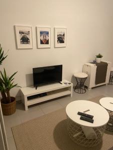 a living room with a flat screen tv on a white entertainment center at Au cœur de St Jean Cap Ferrat in Saint-Jean-Cap-Ferrat