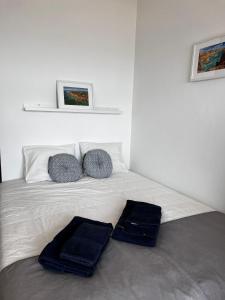 a white bed with two pillows and towels on it at Seaview, beach front, studio in Alvor