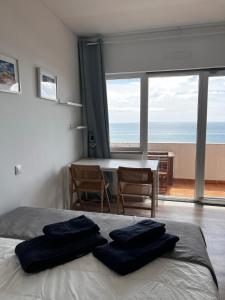 a bedroom with a bed with two blue towels on it at Seaview, beach front, studio in Alvor