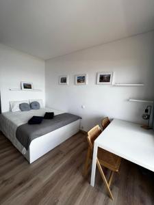 a bedroom with a bed and a desk and a table at Seaview, beach front, studio in Alvor