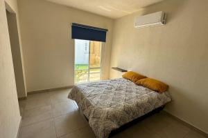 um quarto com uma cama e uma janela em El Rincón Veracruz, Dream Lagoons em Veracruz