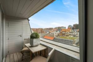 a balcony with a table and a potted plant at Gelsea Blankenberge in Blankenberge