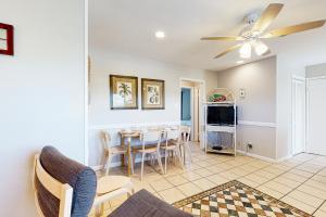 a living room with a ceiling fan and a dining room at Seahorse 612 in Gulf Shores