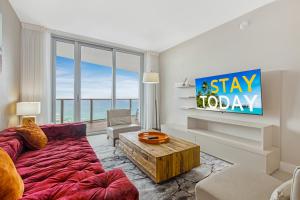 a living room with a couch and a tv at EXCLUSIVE RESORT - OCEANFRONT 2BD 2BA CONDO, HiGH FLOOR, ROOFTOP POOL AND HOT TUB, STEPS TO BEACH in Hollywood +55 photos