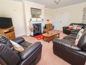 a living room with leather furniture and a fireplace at Middlegate in Ryton
