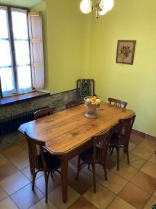 una mesa de madera con sillas y un bol de fruta. en Casa Abedul, en Puebla de Lillo