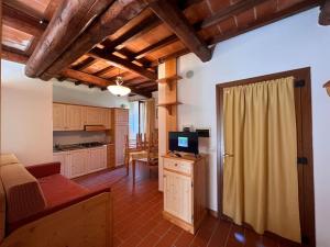 a living room with a couch and a television at Rifugio Rustico Relax in Parco Privato - free parking - privacy TG4 in Castel del Piano