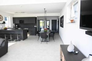 a kitchen and living room with a table and chairs at Robson Beach I Sauna, Jacuzzi in Międzywodzie