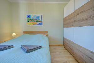 ヘルにあるHelApart- Zatokaのベッドルーム1室(大型ベッド1台、青いシーツ付)
