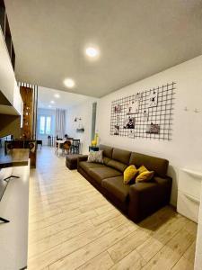 a living room with a brown couch and a kitchen at La Casina Di Lucio in Laterina