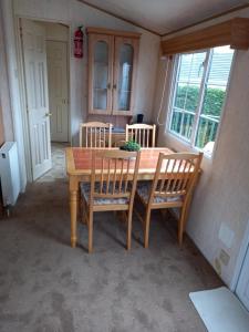 una sala da pranzo con tavolo e sedie in legno di Adorable Caravan in Western Lakes a Workington