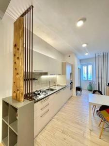 a large kitchen with white cabinets and a table at La Casina Di Lucio in Laterina