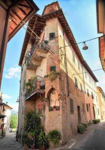 um antigo edifício de tijolos com uma varanda numa rua em La Casina Di Lucio em Laterina