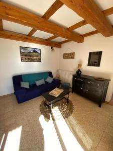 salon z niebieską kanapą i stołem w obiekcie Gîte Lou Pastre w mieście Aureille