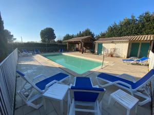 patio z krzesłami i basenem w obiekcie Gîte Lou Pastre w mieście Aureille