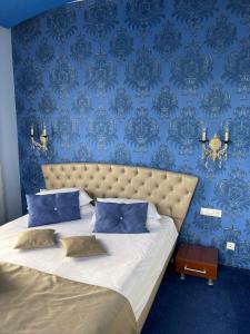 a bedroom with a bed with a blue wall at Casa Dunarea by Genco in Predeal