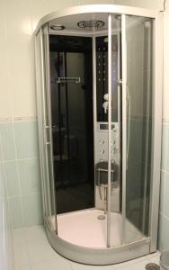 a shower in a bathroom with a glass door at City Inn Residence in Timişoara
