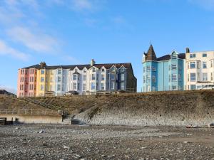 a large building sitting on top of a beach at Garreg Wen in Criccieth
